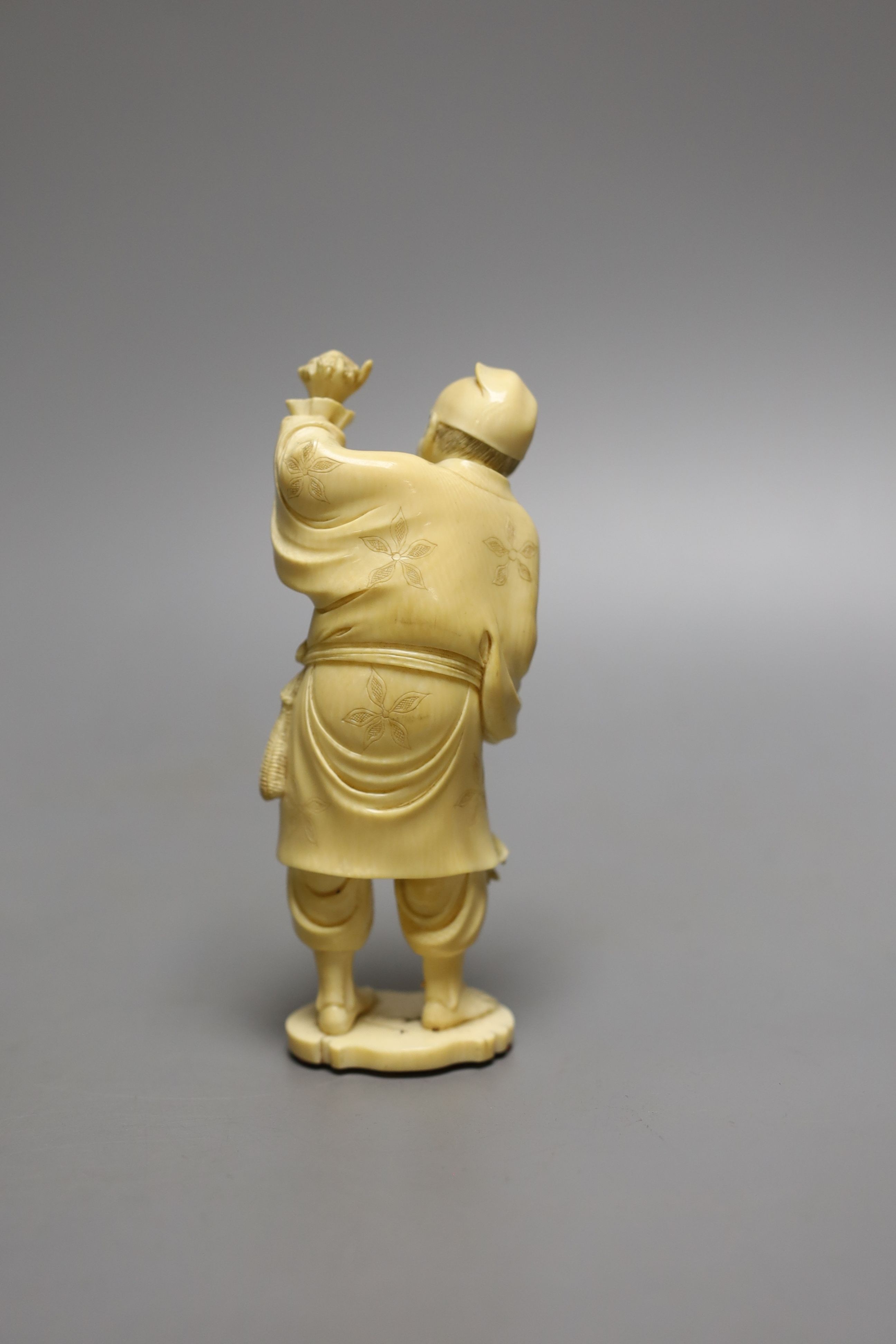 A Japanese ivory okimono of a man holding a turtle or terrapin, Meiji period - 13.5cm tall